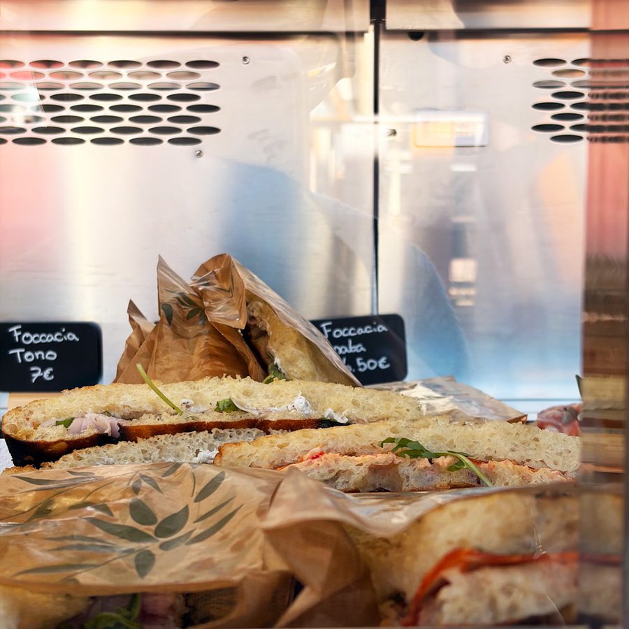 Focaccias garnies coupées en deux, présentées en vitrine