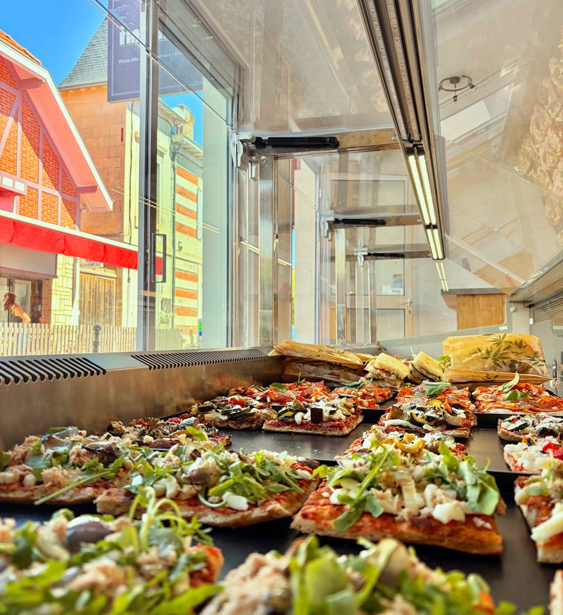 La vitrine d'Impasto garnie de pizzas alla pala et de focaccias
